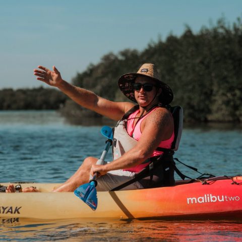 a man riding on the back of a boat in a body of water